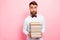 Photo of exhausted uncertain unsure guy holding big amount of books in hands isolated pastel background