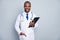 Photo of family doctor dark skin guy cheerful beaming smile tell advice patients hold clipboard prescription test