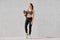 Photo of fitness woman with perfect body shape, holds exercise mat, going in sport gym for having training, wears sneakers and spo