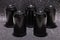 Photo of five black blank aluminium cans, front view