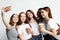 Photo of five multiethnic  girls laughing and  taking selfie