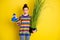 Photo of flirty nice brunette girl blow kiss hold plant spray wear rainbow sweater blue pants isolated on bright yellow