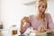 Photo of focused beautiful woman reading book while having breakfast