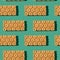 Photo in the form of a seamless pattern. Orange color loafs for healthy food with shadows on a green background.