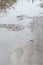 Photo of a fragment of a destroyed road with large puddles in rainy weather