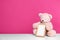 Photo frame and adorable teddy bear on table against color background. Child room elements