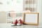 Photo frame and bootees on table in baby room interior