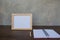 Photo Frame on a wooden table and book on Gray wall background .