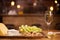 Photo of fresh grapes next to a wineglass on a wooden table