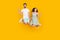 Photo of friendly couple jump hold hands enjoy flight show v-sign wear casual outfit isolated yellow color background