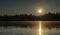 The photo of frozen crystal clear lake is intentionally darkened by sun lens filter to show the real size of the Sun rays. Low sun