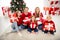 Photo of full big family five people gathering three small kids sit floor hold colorful presents smile wear red jumper