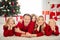 Photo of full big family five people x-mas gathering three small kids hug hold hand cheeks lie floor carpet wear red