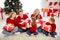 Photo of full big family five people meeting three little kids sit carpet hold exchange presents girl wear red jumper