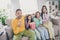 Photo of full family four people sit sofa eat popcorn watch movie scared wear colorful pullover in living room indoors