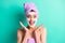 Photo of funky astonished girl foam mask open palms face wear violet towel turban isolated teal color background