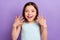 Photo of funky brown hairdo small girl hands up wear blue top isolated on violet color background