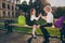 Photo of funky carefree schoolchildren sit bench play hand clapping wear school uniform nature park outside