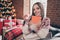 Photo of funky charming mature woman wear print sweater smiling enjoying new year book indoors house home room