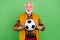 Photo of funky charming senior gentleman wear yellow vest playing football smiling isolated green color background