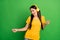 Photo of funky crazy young woman sing dance pop music wear headset isolated on green color background