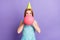 Photo of funky happy young woman blow air balloon party decoration inflate isolated on purple color background