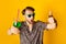 Photo of funky impressed gentleman dressed print shirt dark glasses drinking cocktail pointing you isolated yellow color