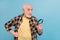 Photo of funky interested man pensioner dressed checkered shirt looking enlarging glass empty space isolated blue color