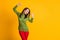 Photo of funky lady raise arms good mood party wear green sweater red trousers isolated yellow color background