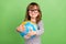 Photo of funky little blond hair girl hold globe wear striped shirt isolated on green color backgound
