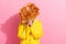 Photo of funky shy lady wear raincoat close eyes orange leaves bunch empty space isolated pink color background