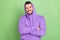 Photo of funky young brunet guy crossed hands wear violet hoodie isolated on green color background