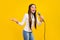 Photo of funny charming preteen girl dressed white zipper shirt singing karaoke smiling  yellow color background