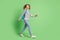 Photo of funny charming small schoolgirl dressed striped sweater rucksack walking isolated green color background