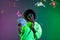 Photo of funny cool dark skin lady dressed sweatshirt eyewear arm earphones holding cash isolated neon background