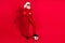 Photo of funny cool man dressed christmas costume hat arms folded playing football empty space isolated red color