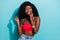 Photo of funny cunning dark skin lady wear red crop top smiling biting lip looking empty space isolated blue color