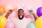 Photo of funny dark skin guy colorful decorations easter party festive mood open mouth directing fingers head fluffy