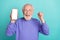 Photo of funny delighted person raise fist celebrate achievement empty space phone screen isolated on cyan color