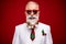 Photo of funny elder white hair santa man balls on beard wear eyewear white jacket isolated on red color background