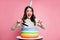 Photo of funny excited lady arm hold knife fork cut colorful cake open mouth isolated on pastel pink background