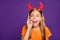 Photo of funny little lady headband horns on head sharing rumours wit classmates chatterbox october party wear orange t-