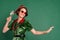 Photo of funny pretty young woman dressed elf costume glasses smiling drinking champagne dancing isolated green color