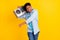 Photo of funny sweet dark skin guy dressed denim shirt smiling dancing singing listening boom box isolated yellow color