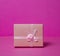 Photo of a gift box with a bow under points of view on a pink background front view