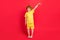 Photo of ginger adorable little boy hand measure empty space wear yellow t-shirt isolated red color background