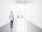 Photo of girl in empty contemporary gallery looking at the blank white canvas. Big windows, spotlights, concrete floor