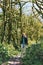 Photo of a girl walking along the trail path through boxwood forest