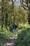 Photo of a girl walking along the trail path through boxwood forest