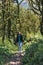 Photo of a girl walking along the trail path through boxwood forest